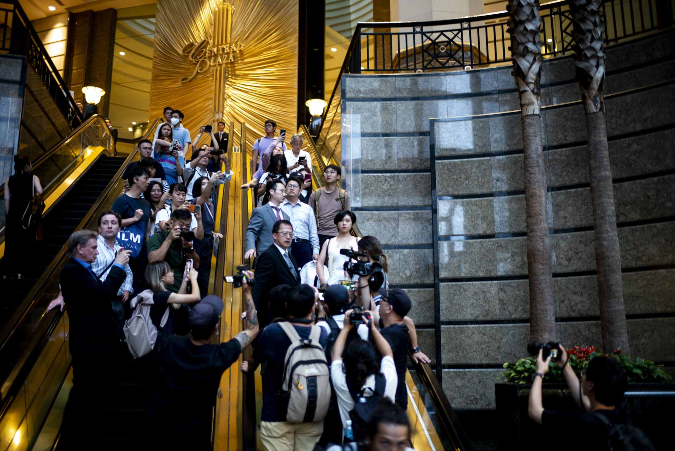 2024年7月17日,香港記者協會主席鄭嘉如遭《華爾街日報》辭退後,離開中環廣場的辦公室,被大批傳媒追訪。攝:林振東/端傳媒