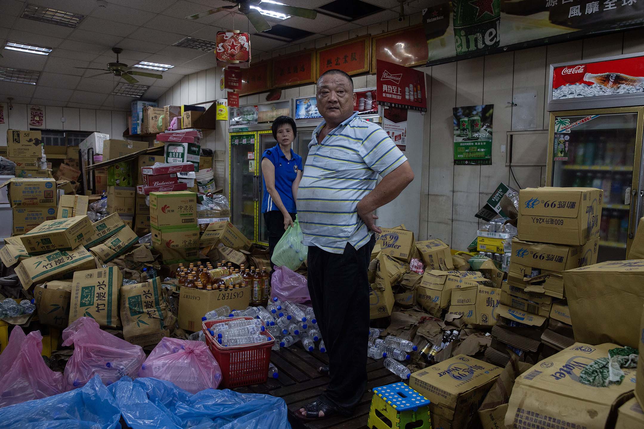 2024年7月27日,台南鹽水,淹水後的一間超市,老闆在整理災後的店。 攝:陳焯煇/端傳媒