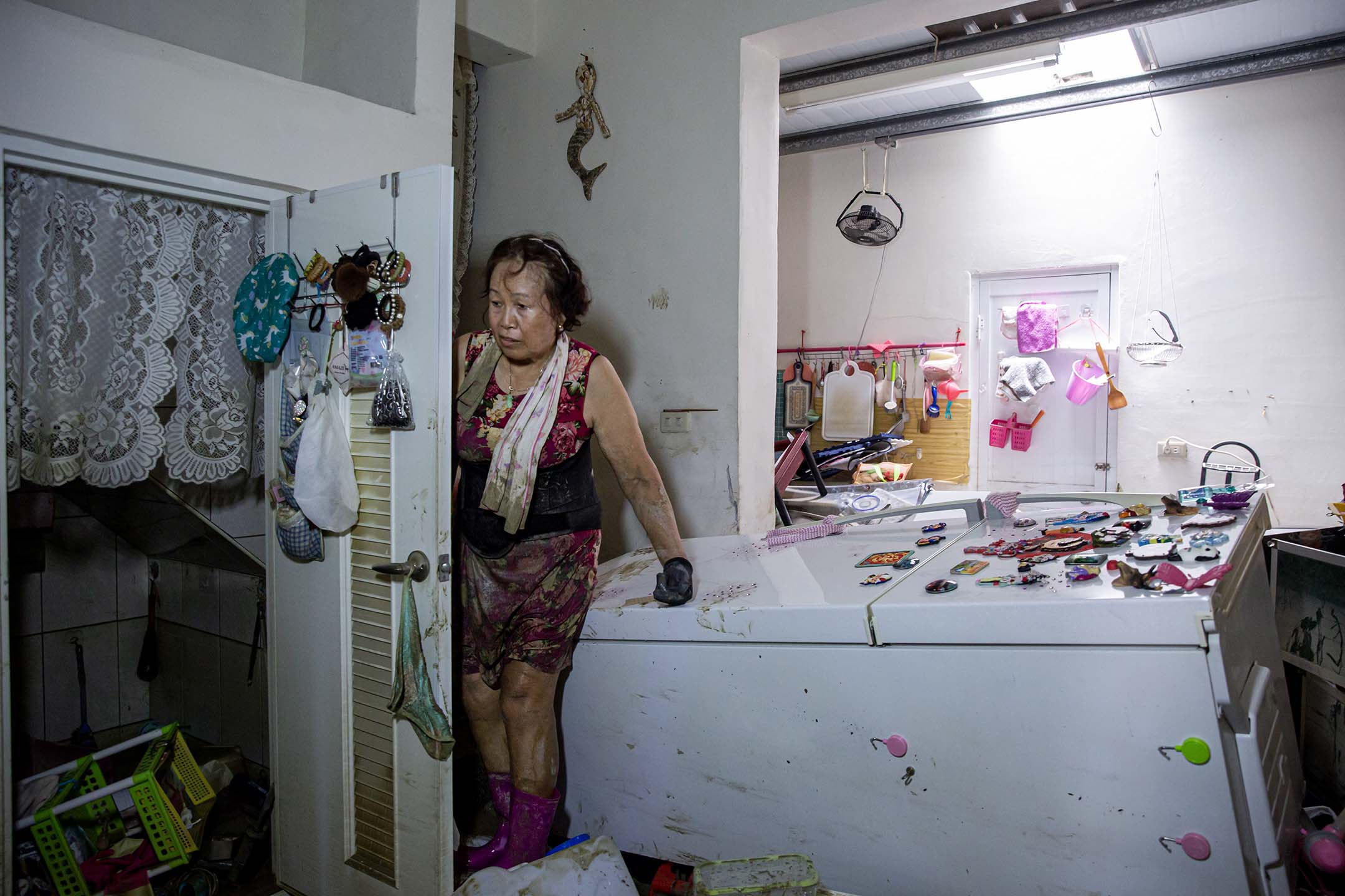 2024年7月27日,嘉義水上鄉,居民在淹水後的房子內收拾。 攝:陳焯煇/端傳媒