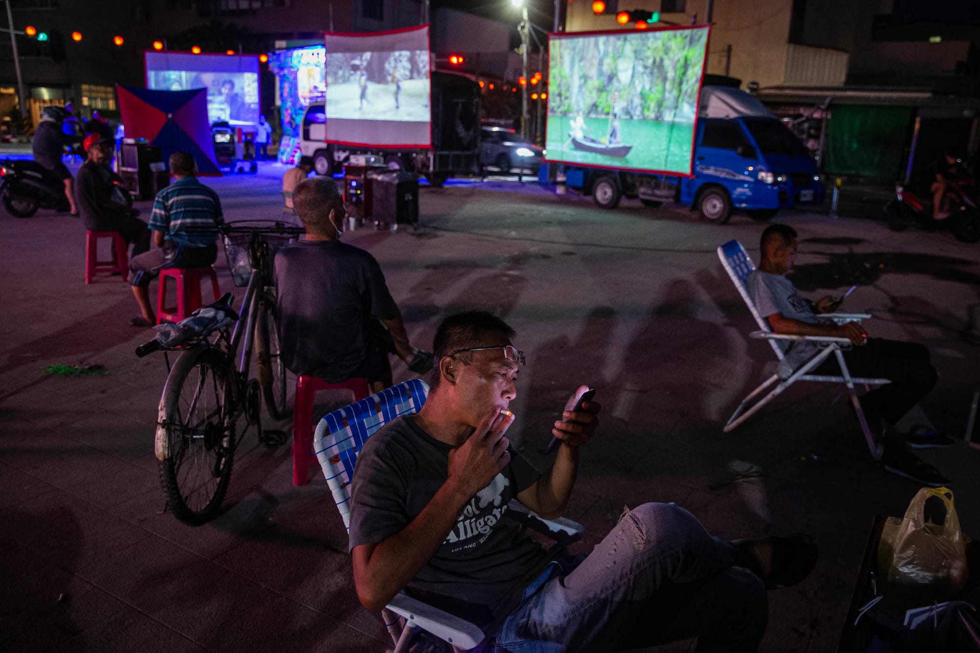 2024年7月27日,台南鹽水,水退後的鹽水武廟,人們在廟前看電影。攝:陳焯煇/端傳媒