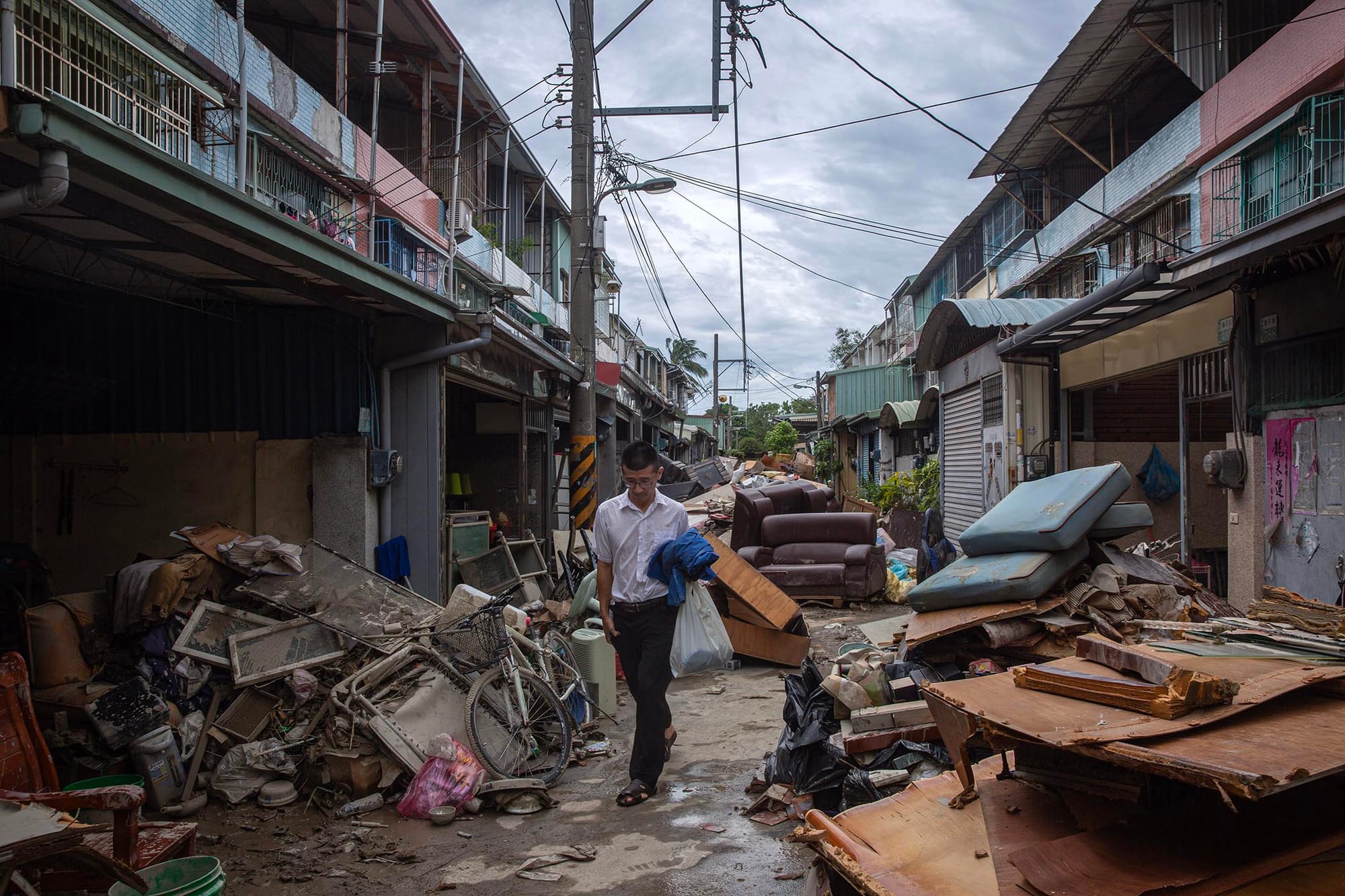 2024年7月27日,嘉義水上鄉,淹水過後,一個社區內佈滿棄置的家具和垃圾。攝:陳焯煇/端傳媒