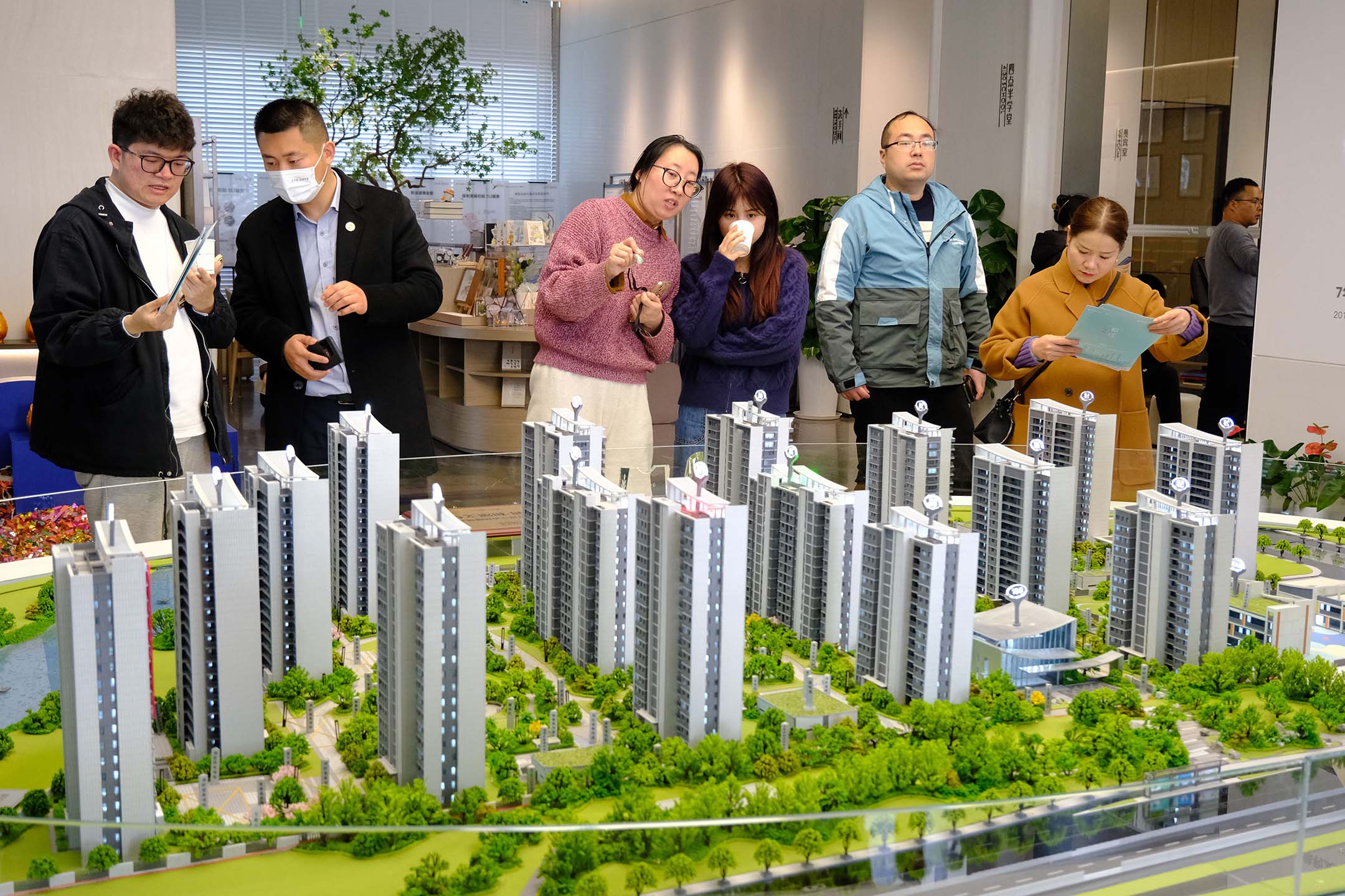 2023年3月4日,中国浙江省宁波市,人们在销售处观看住宅建筑模型。摄:VCG/VCG via Getty Images