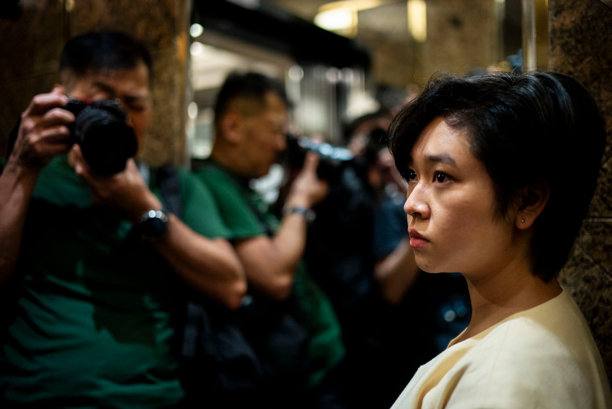 2024年7月17日,香港記者協會主席鄭嘉如遭《華爾街日報》辭退後,離開中環廣場的辦公室,被大批傳媒追訪。攝:林振東/端傳媒