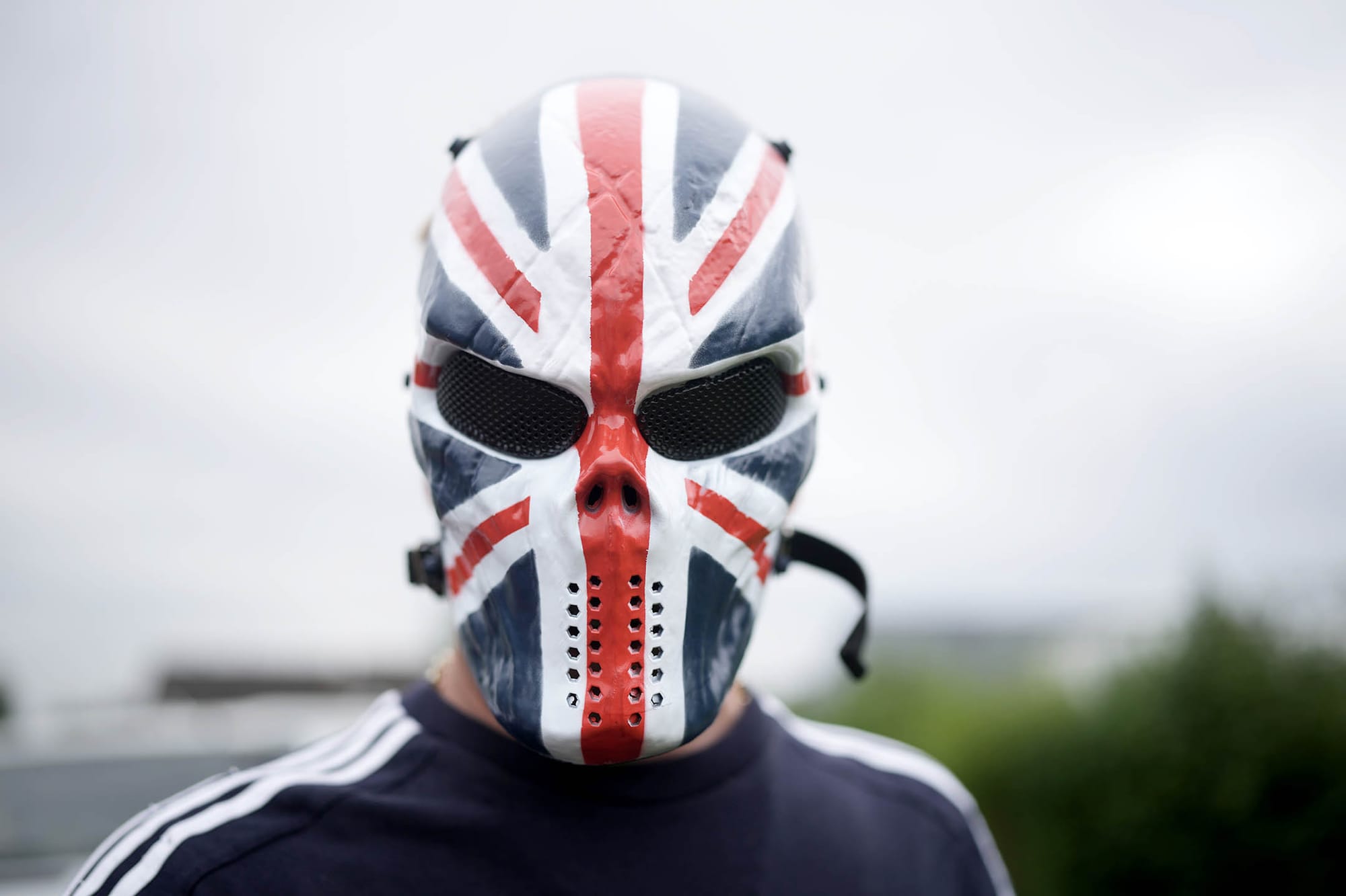 2024年8月4日,英國羅瑟勒姆,一名戴著英國國旗面具的反移民示威者在酒店外示威。攝:Christopher Furlong/Getty Images