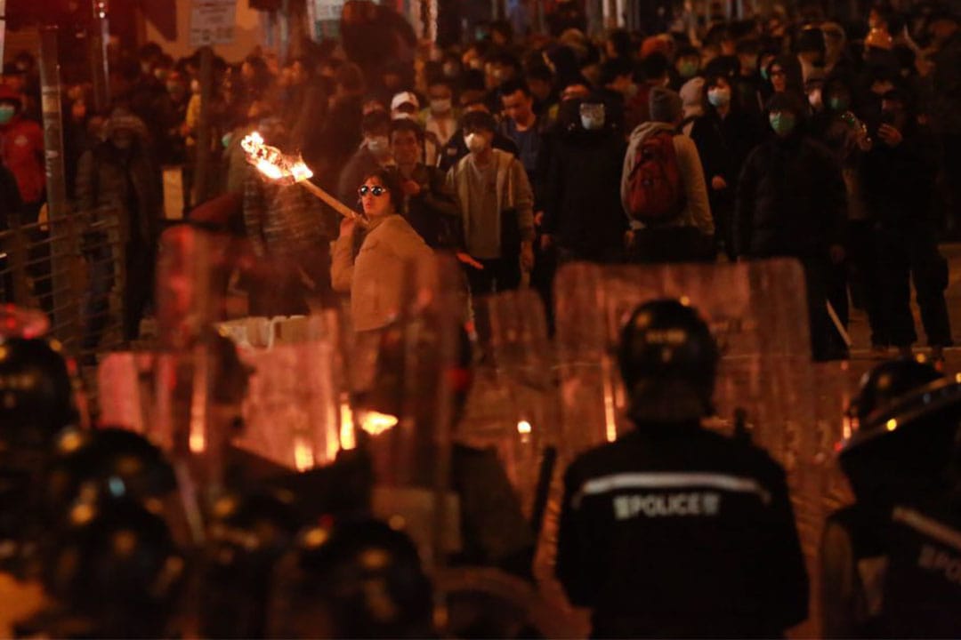 凌晨约5时，有示威者用竹枝做成火把投向警察。摄：Billy.H.C.Kowk/端传媒
