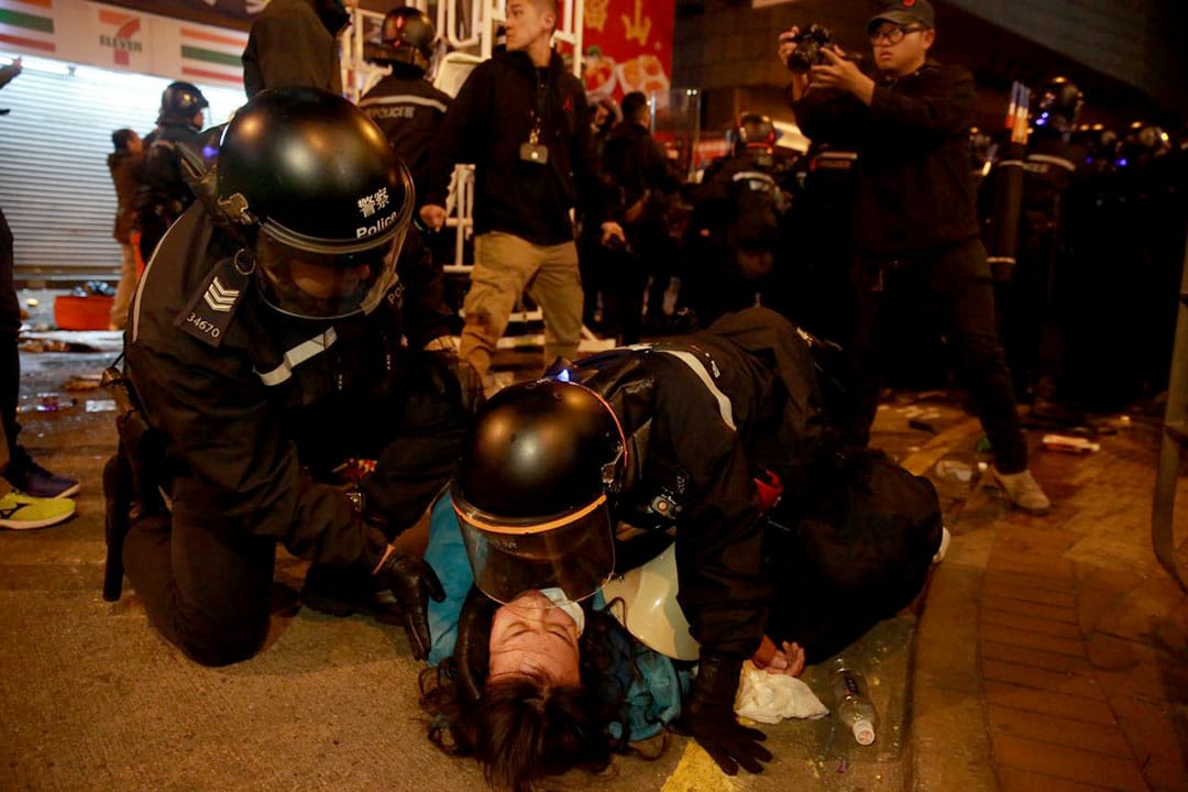  2016年2月9日凌晨二时，旺角，警员制服一名手持扩音器的示威者。摄：Billy H.C. Kwok/端传媒