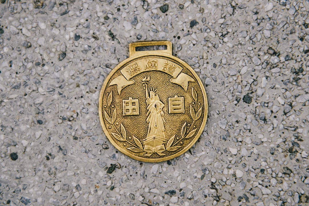 吴明益的老铁马局部细节，与他所收藏的早期脚踏车车牌、保险牌。摄：赵豫中/端传媒