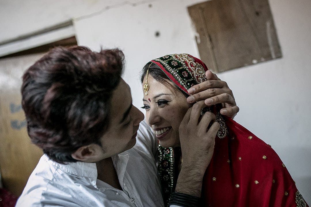 2015年，結婚前夕，印尼女生穿上傳統服飾，丈夫為她整理衣裳。攝: Billy H.C. Kwok/ 端傳媒