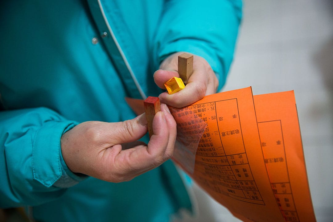 投票當天,謝素嬉拿著印章與通知單到投票站。攝:Billy H.C. Kwok/端傳媒