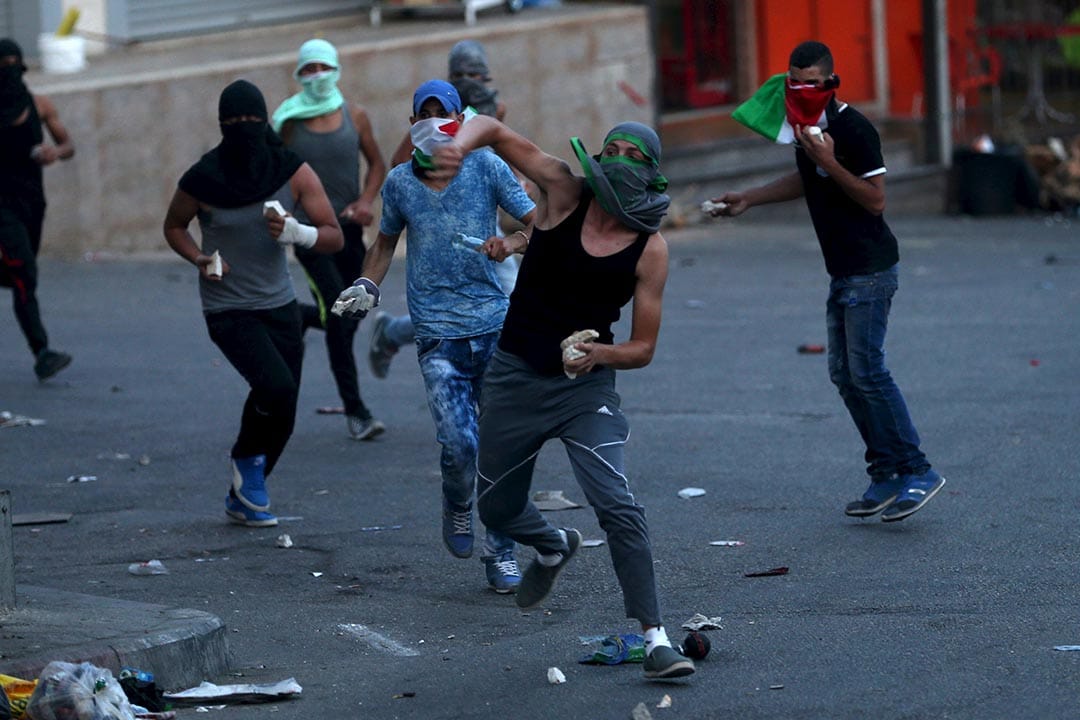 2015年9月30日，约旦河西岸，巴勒斯坦示威者向以色列保安部队投掷杂物。摄:Mohamad Torokman/REUTERS