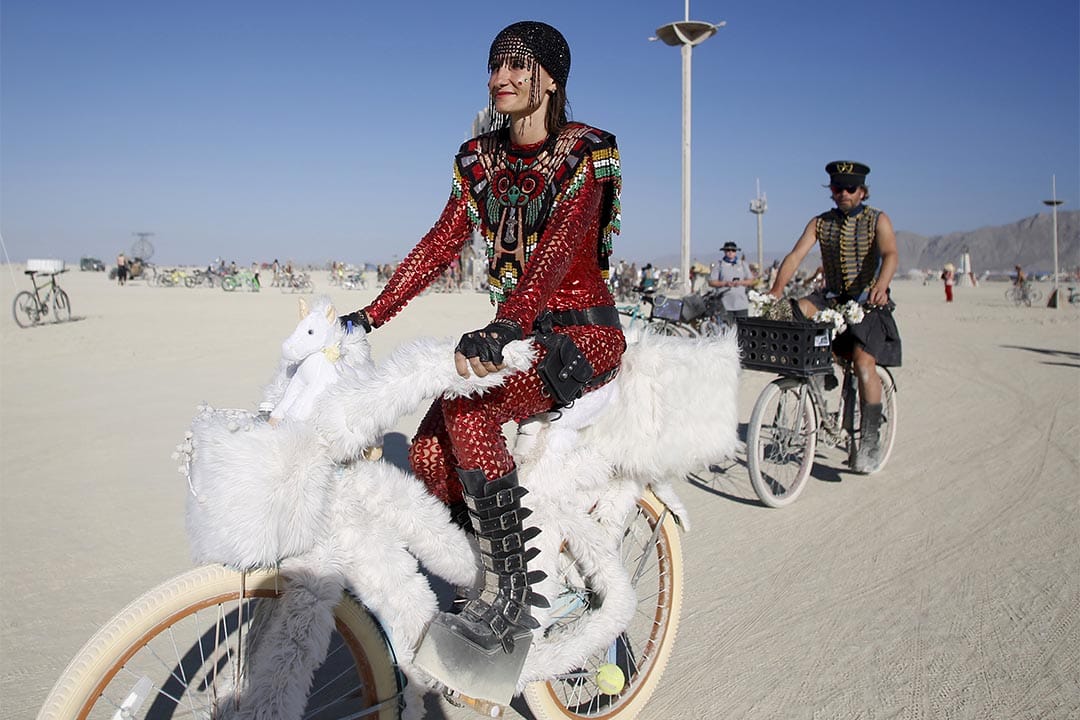 Burning Man（火人祭）參加者穿上盛裝在場內踏單車。攝：Jim Urquhart/Reuters