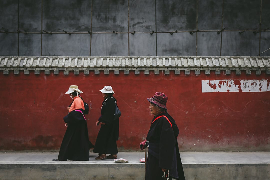 幾位藏族群眾從新寨嘉那嘛呢石堆附近走過。攝 : 王嘉豪/端傳媒