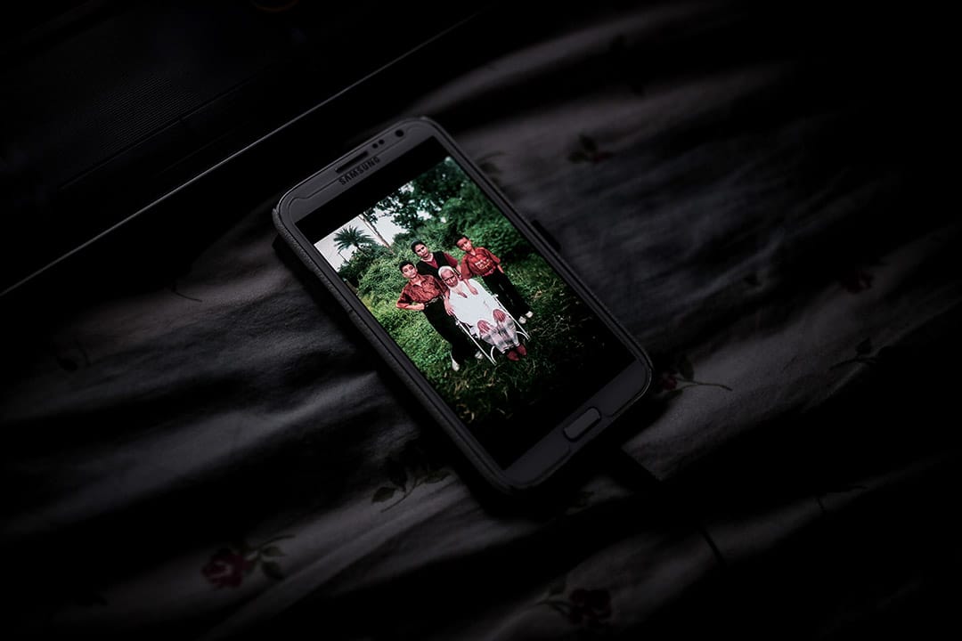 一位尋求庇護者手機裡面的照片，照片是他年輕時與弟弟、母親和祖父合照。攝: Billy H.C. Kwok/ 端傳媒