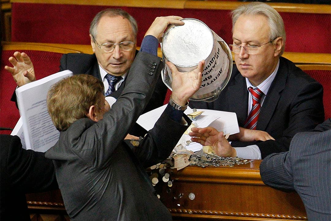 乌克兰议员将一桶钱币倒向一名政府官员。摄：Sergey Svetlitsky/REUTERS