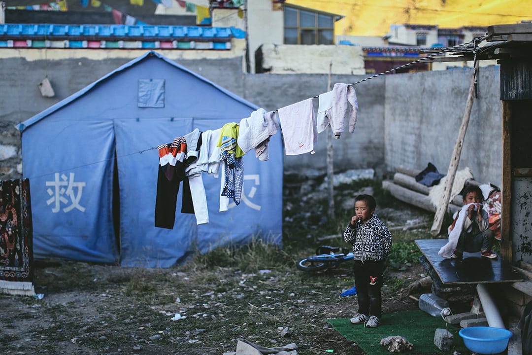 移民村內仍擺放了救灾用的帐篷。攝 : 王嘉豪/端傳媒