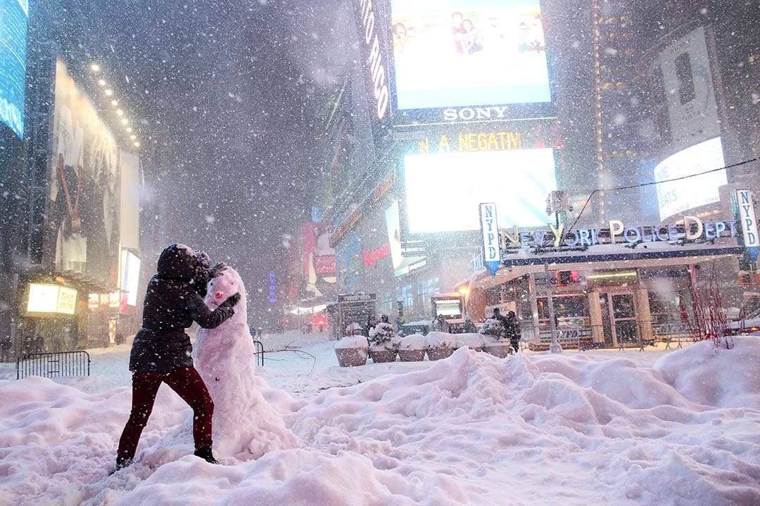 2016年1月23日，紐約時代廣場，一名女子在行車路上堆砌雪人。攝：Yana Paskova/Getty Images