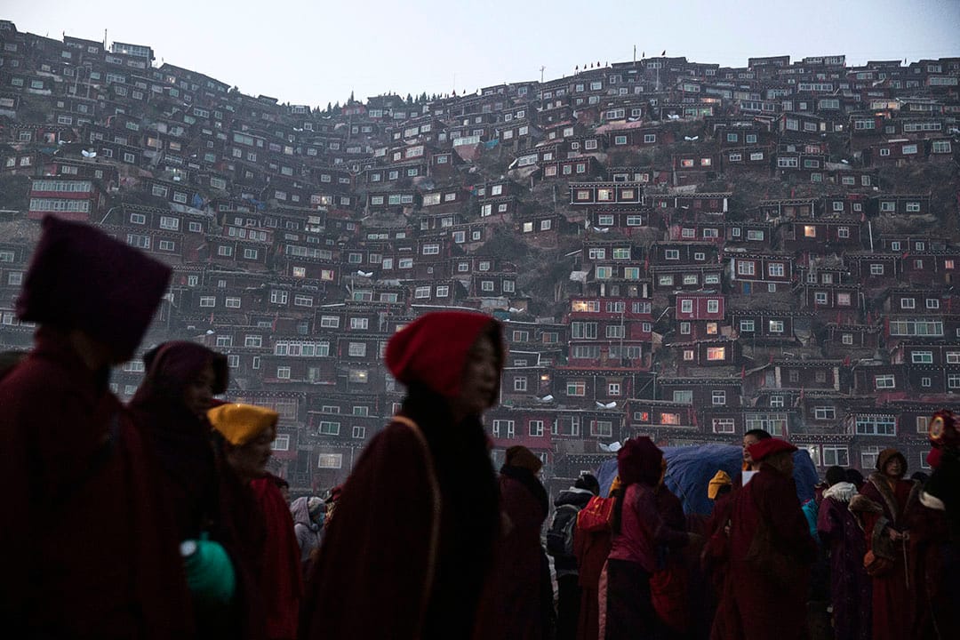 喇嘛和覺姆們離開佛學院,沿著黑暗的路回家。攝:Kevin Frayer/Getty Images