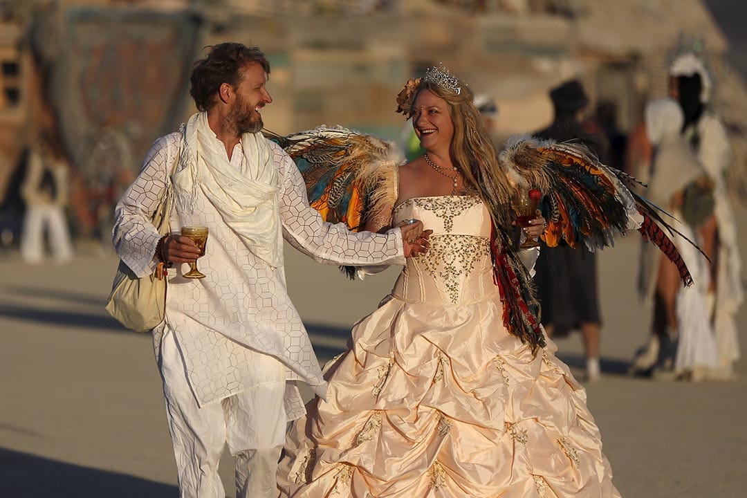 日出時分，有參加者穿上盛裝，於沙漠上行走。攝：Jim Urquhart/Reuters