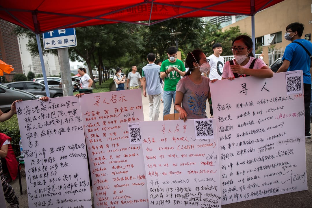 當地居民在紙板上寫上失縱親友的聯絡方法。