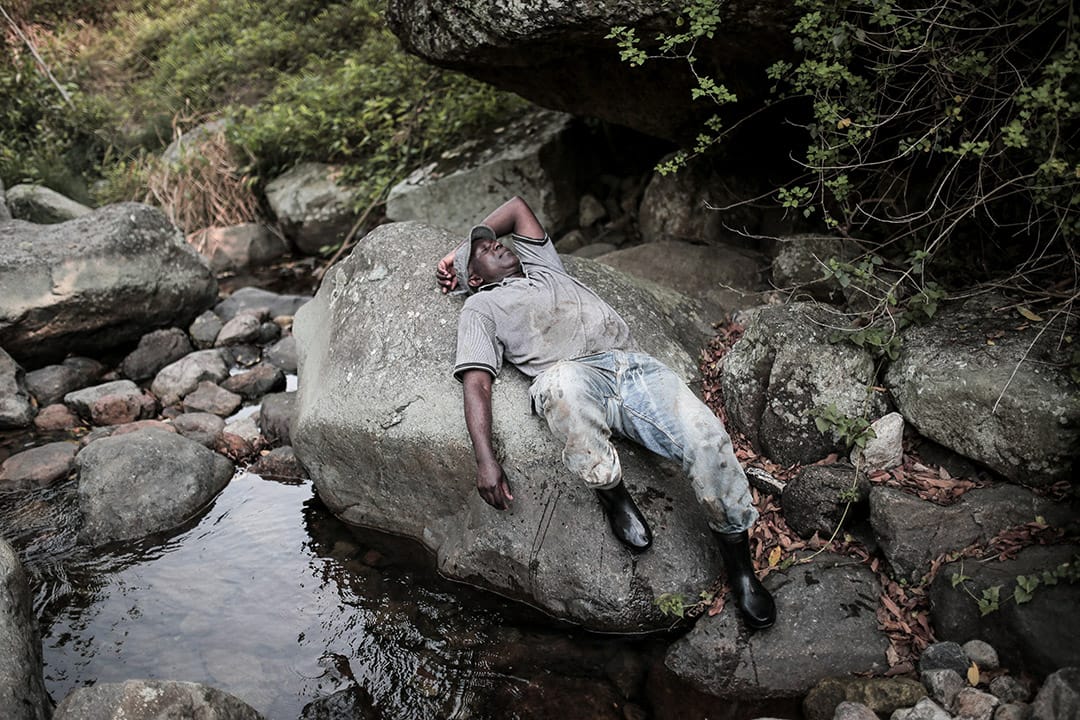 一位難民於大石上休息。攝: Billy H.C. Kwok/ 端傳媒