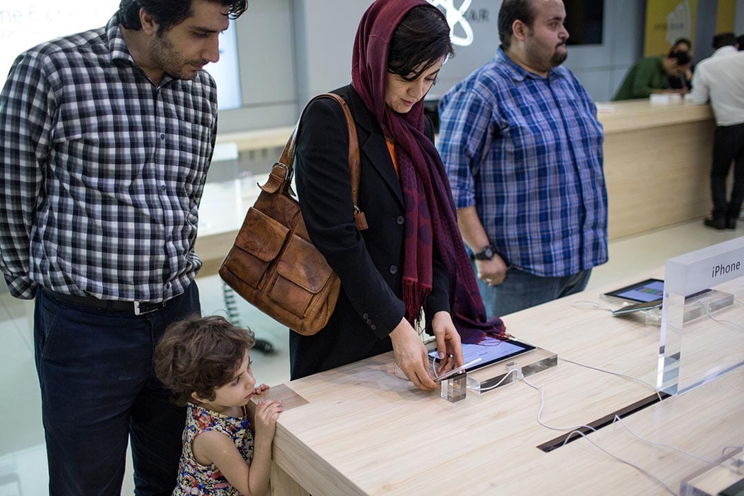 一名婦女在德黑蘭的電話店測試iPhone的功能。攝: Arash khamooshi /端傳媒