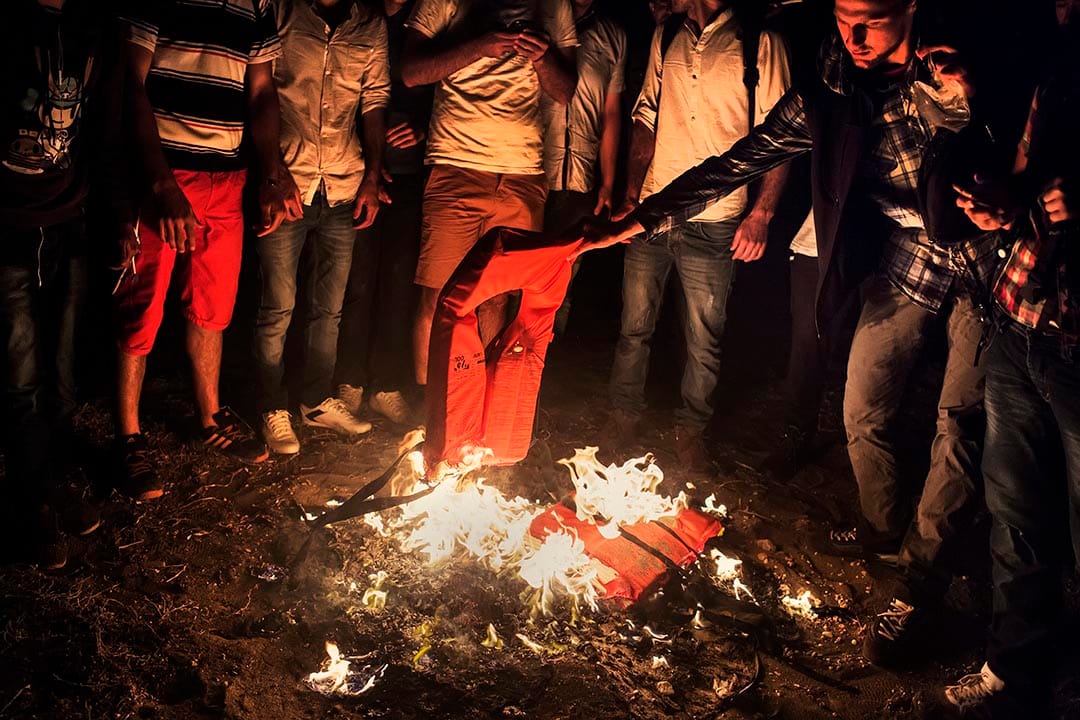 剛抵埗的敘利亞人焚燒救生衣取暖。他們在島上較偏遠的地方登岸，因此除了取暖外，亦希望以火光吸引海岸防衛隊的注意。摄：Alessandro Penso/MSF