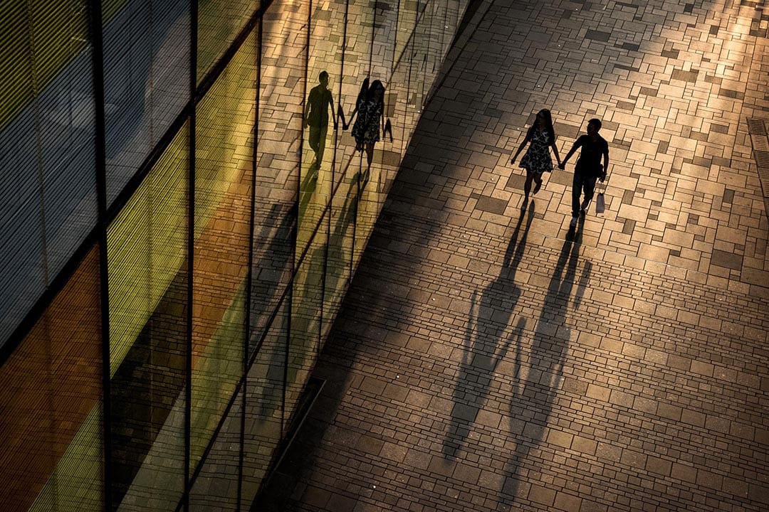 一對情侶在北京的商場外走過。攝:Kevin Frayer/Getty