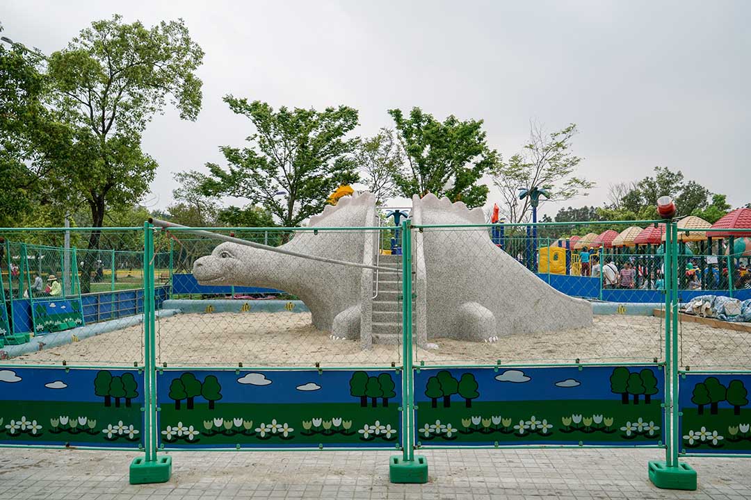 大安森林公園遊戲場原本規劃一座塑膠遊具所在處，在一群父母抗議之下，改為一組恐龍磨石子溜滑梯。攝：張國耀/端傳媒