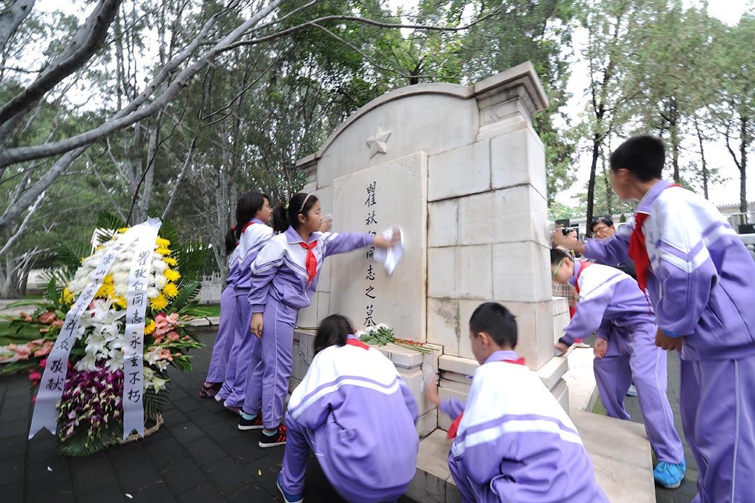 北京八寶山革命公墓，學生打掃瞿秋白的墓碑。