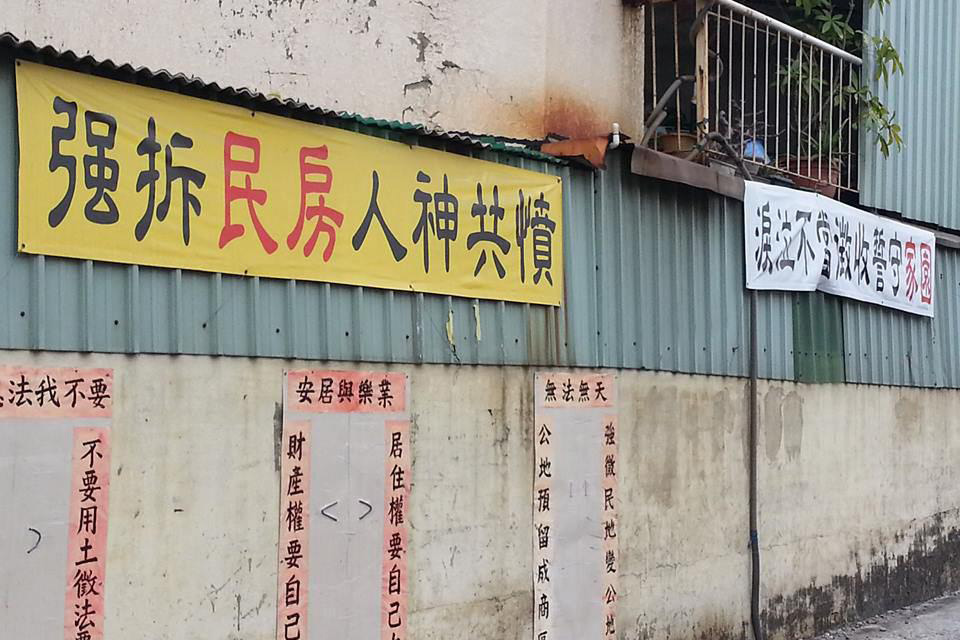 鐵路沿線居民在住家外掛滿反對迫遷的布條。