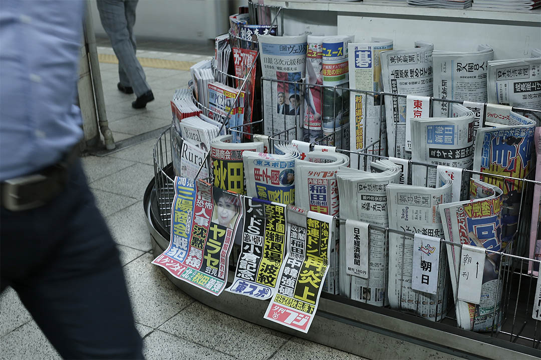 2016年8月3日，日本東京，人們走經一個報攤。