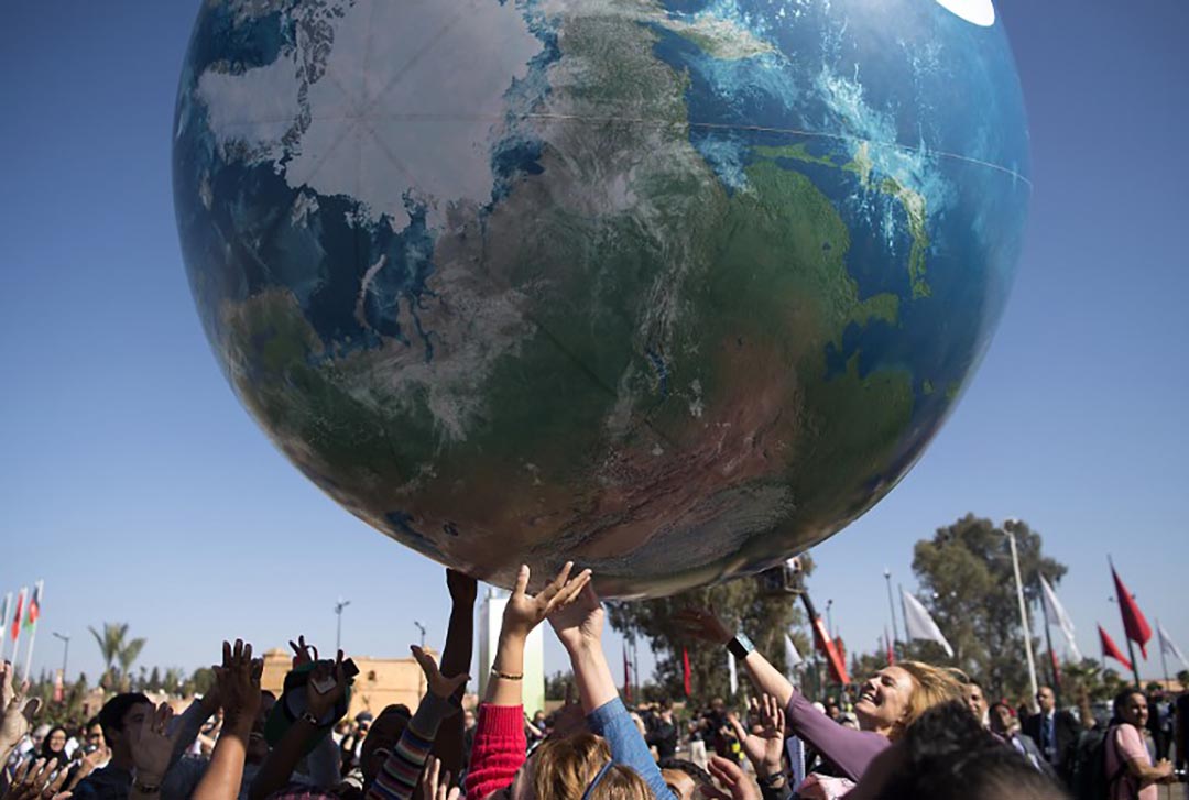 各國國際代表團成員在COP22場外玩一個巨大的地球模型。