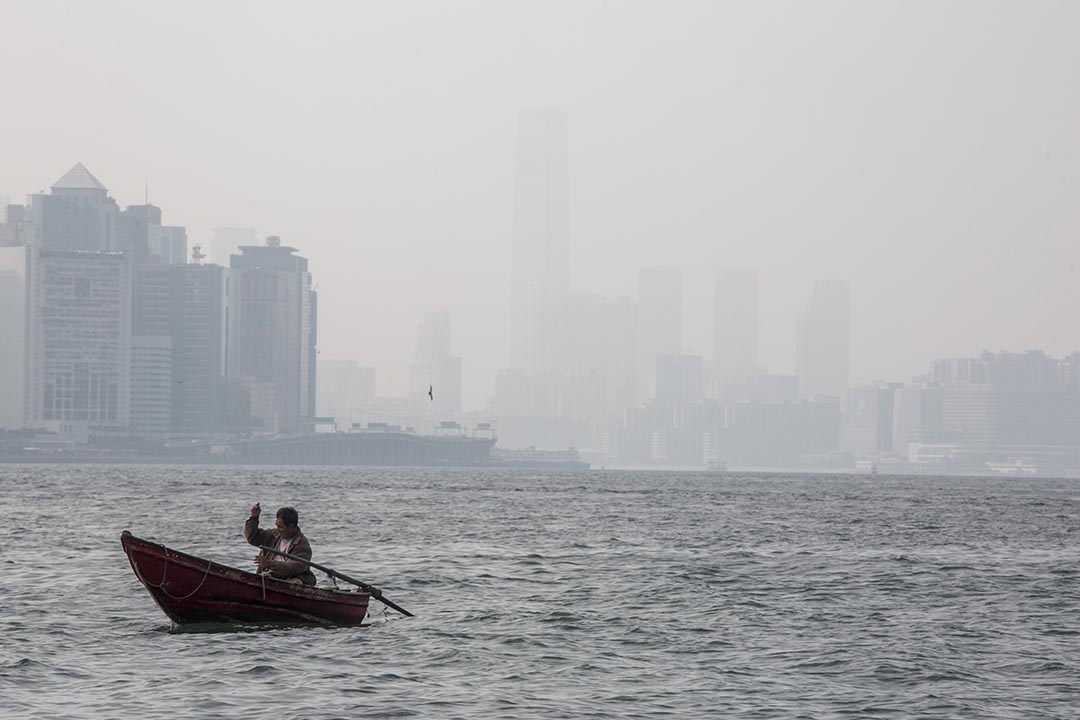 在鲤鱼门对出海面,一名男子在划船垂钓。