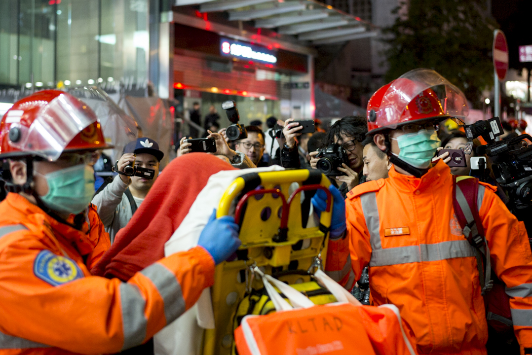 港鐵縱火案後，救護員在尖沙咀港鐵站外運送傷者往醫院治理。