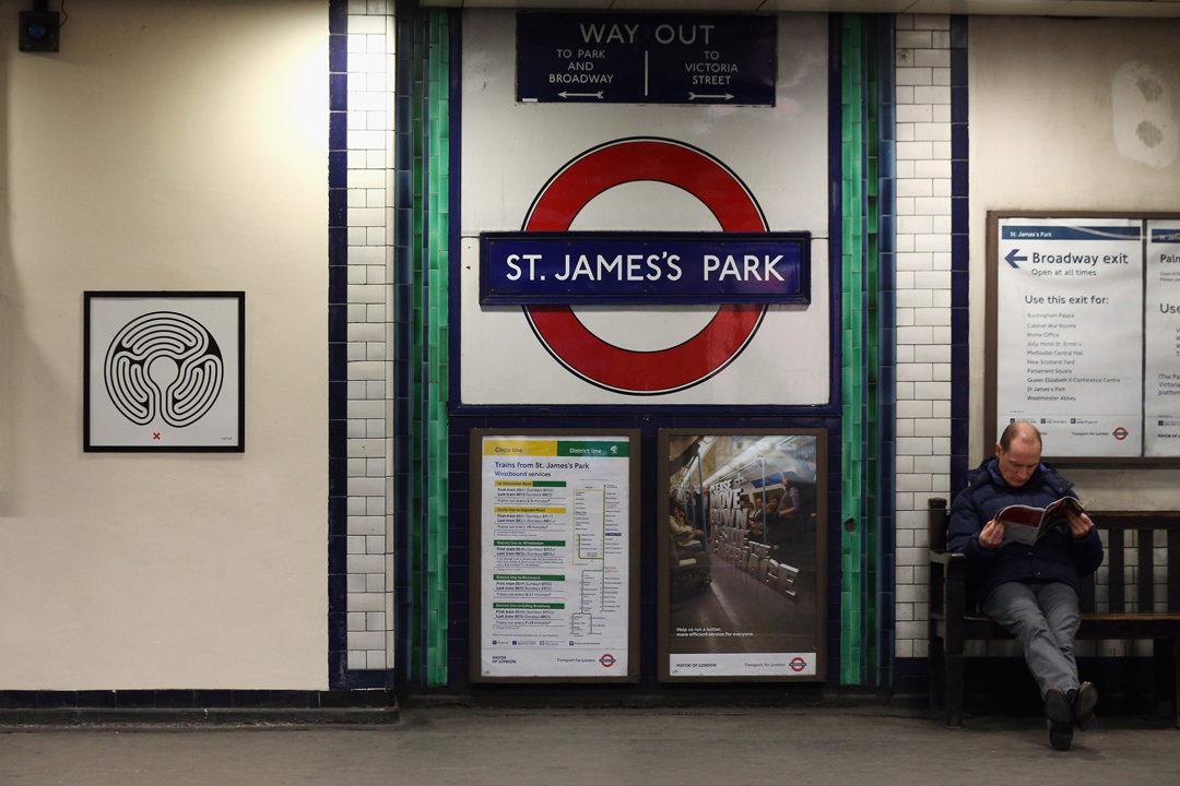 倫敦地鐵St James’s Park Station月台上的一名男子，左方牆面上是英國藝術家Mark Wallinger的作品。