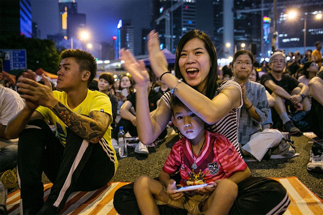 2014年10月18日，在香港，有母親帶同孩子一同於街頭抗議及爭取普選。