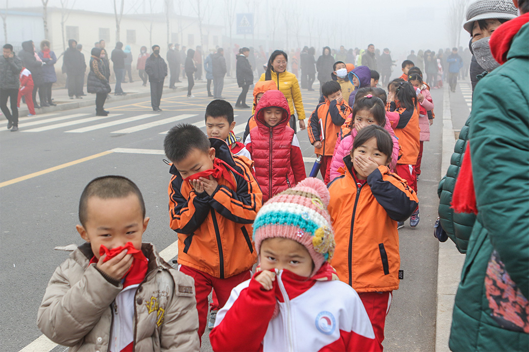 赵亚楠指幼儿园几乎每天都能听到孩子哑着嗓子向老师请病假。图为山东省滨州市，孩子在雾霾下掩着口鼻。