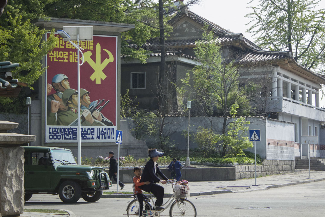 朝鲜旅行团所拍摄的当地街道，一位市民载著小孩踏单车。