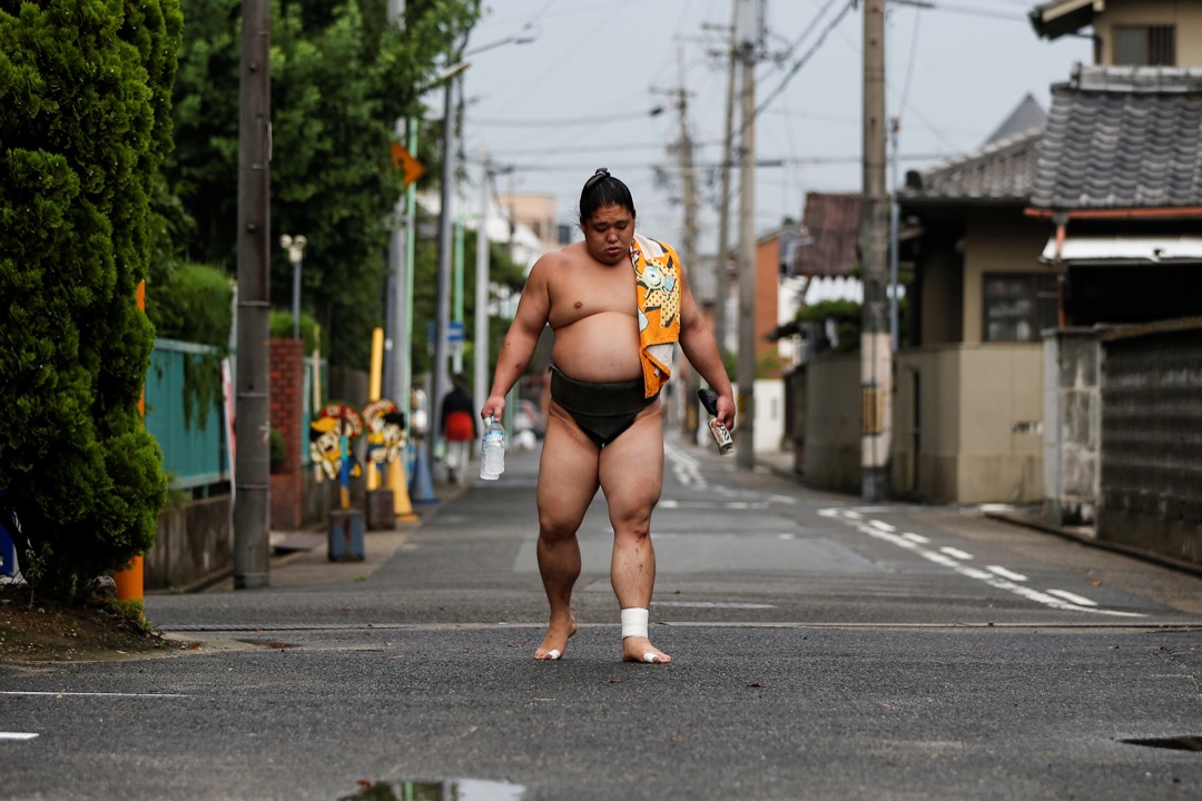 相扑手 Kainishiki 在 Ganjoji Yakushido 寺庙训练完毕后回家。