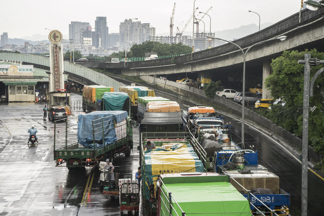 菜車陸陸續續在一市外河堤邊排隊，直到順利卸貨為止。