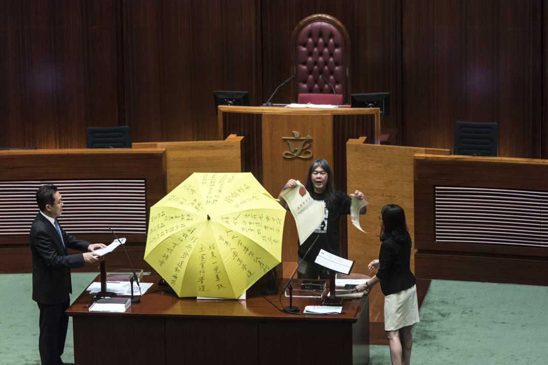 2016年10月12日，香港立法會議員梁國雄於宣誓時，手持黃色雨傘並撕毀一張代表人大831決議的道具。