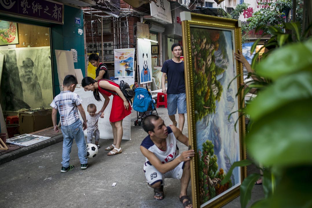 大芬村的下午，街上客人疏落，画师及小朋友在街上踢足球。