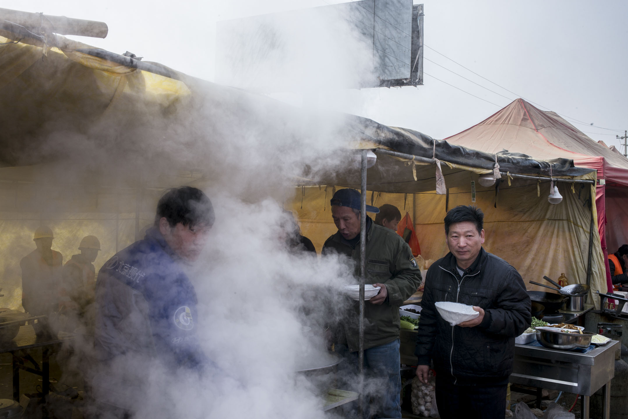 位于容城东部，投资8亿元、占地10万平米的雄安市民服务中心正在热火朝天地赶工。这里将承担雄安新区的政务服务、规划展示、会议举办、企业办公等多项功能。施工中的午饭时间，工人们都在工地外的大食堂吃饭。