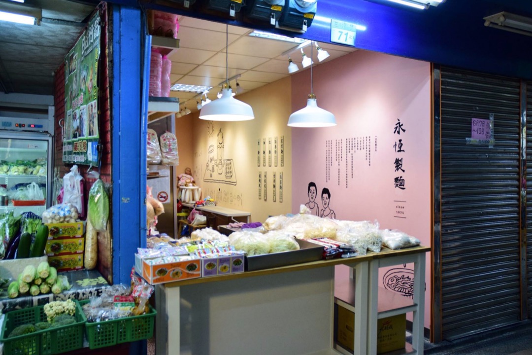 东三水街菜市场翻新，其实跟近年香港领展街市硬件翻新，分别不大。然而细心看下去，硬体以外，我们发现当中有许多围绕店舖特色的设计巧思，像“永恒制面”的档子中，设计利用墙身展示了店子的故事、制面的工序等。这些小细节，著实为整个菜市场的趣味和质感。