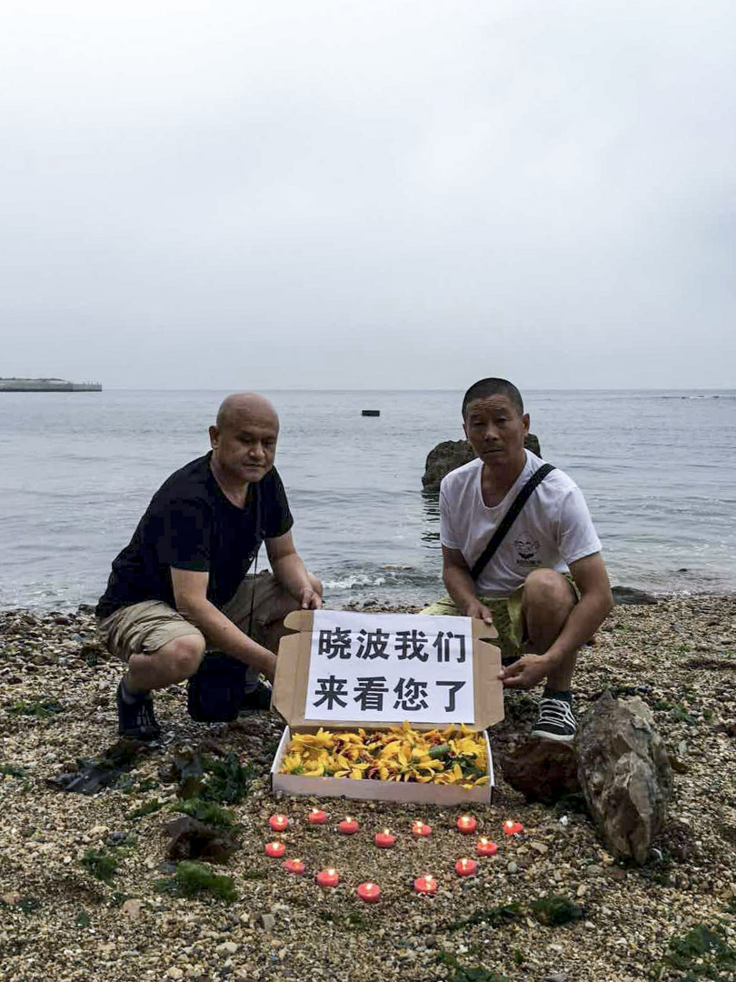 2017年7月18日，遼寧省大連姜建軍、王承剛到當地老虎灘海邊擺放蠟燭、鮮花拜祭劉曉波。