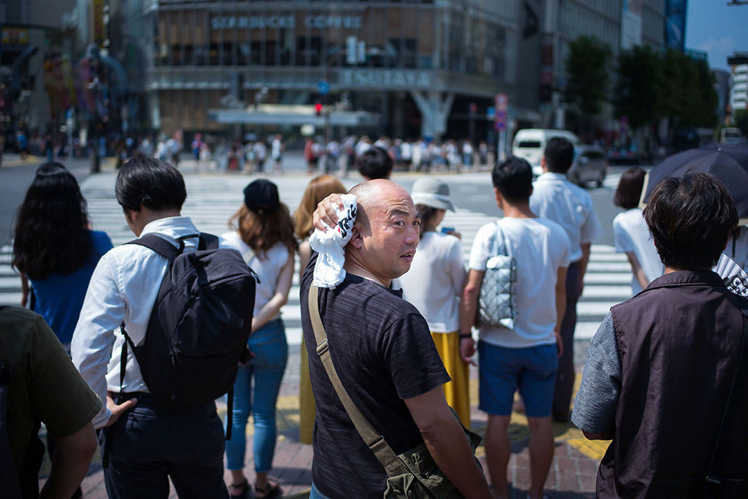 2018年7月24日，日本东京，一名正要过马路的男子在抹汗。