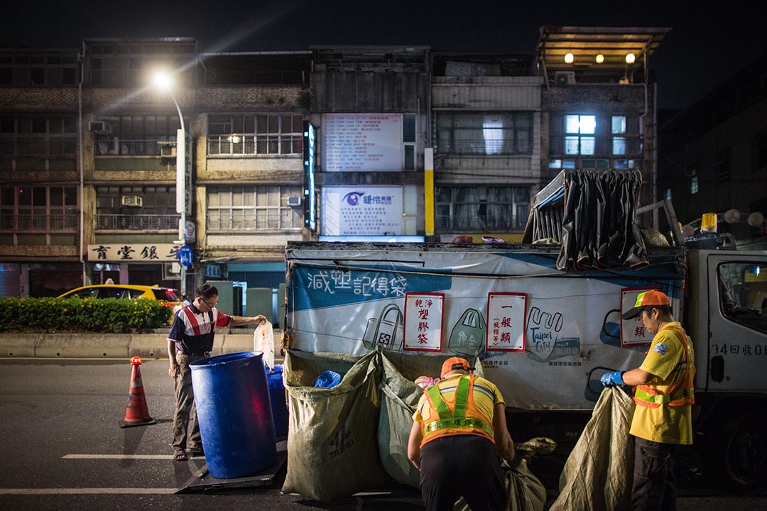 圖為龍山寺的回收車，車身掛置著綠色的大型網袋，隊員正在整理。 