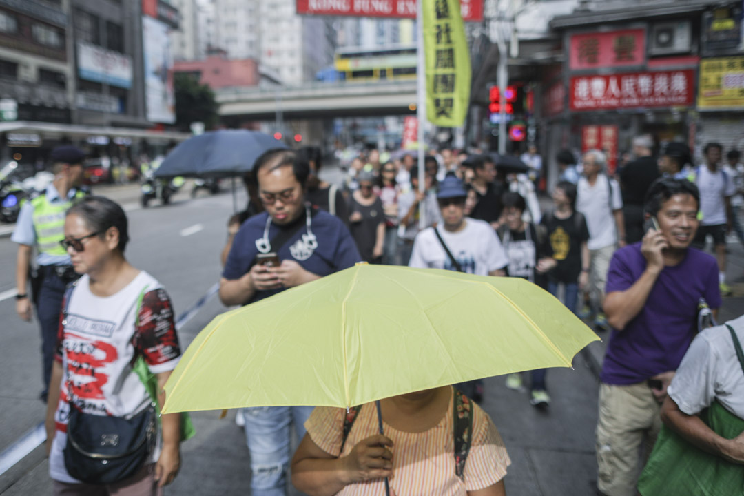 民陣十一遊行，有參加者舉起代表雨傘運動的黃傘參與。