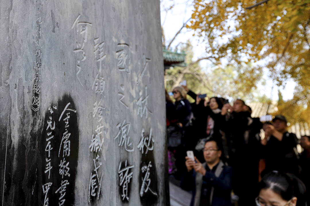 2018年11月2日，河南嵩山少林寺，民众在少林寺天王殿门前的金庸石碑送上菊花，悼念逝世的金庸。