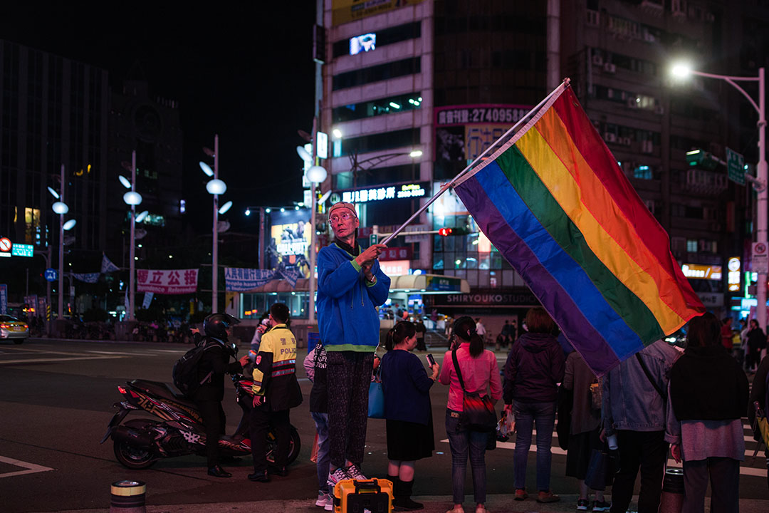 知名同運人士祁家威在公投前於台北西門町高舉彩虹旗。